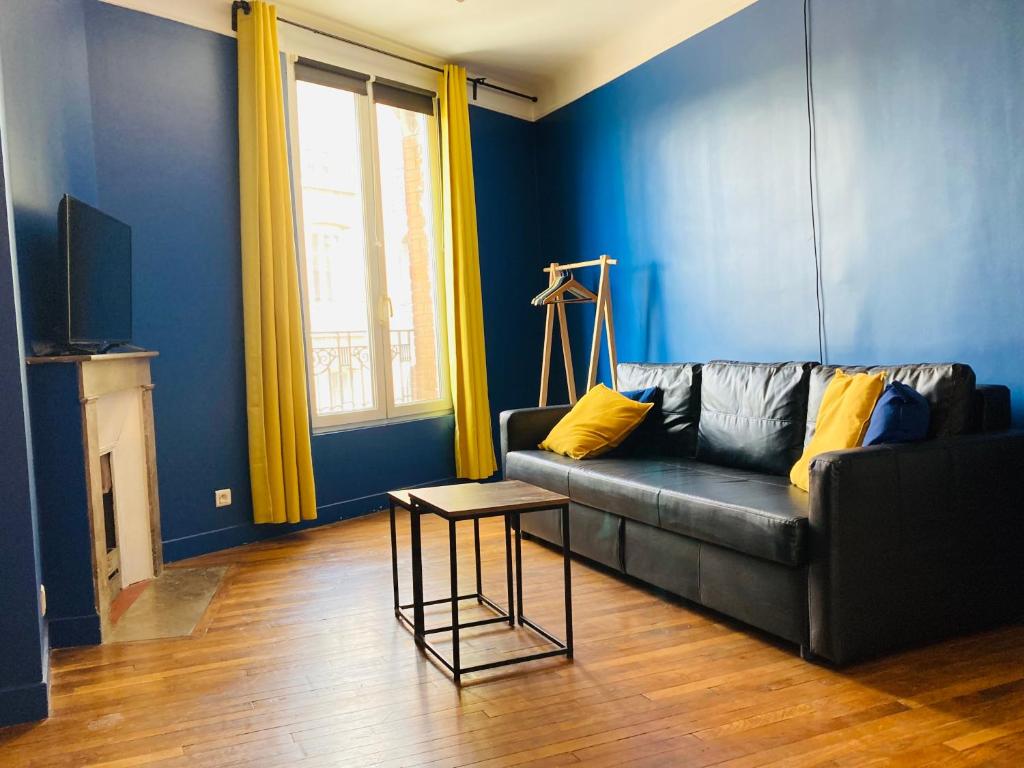 ein Wohnzimmer mit einem Sofa und einem Tisch in der Unterkunft Appartement cosy aux portes de Paris in Montreuil