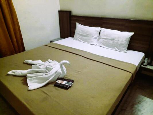 a bed with a swan made out of towels at Hotel Archana in Madurai