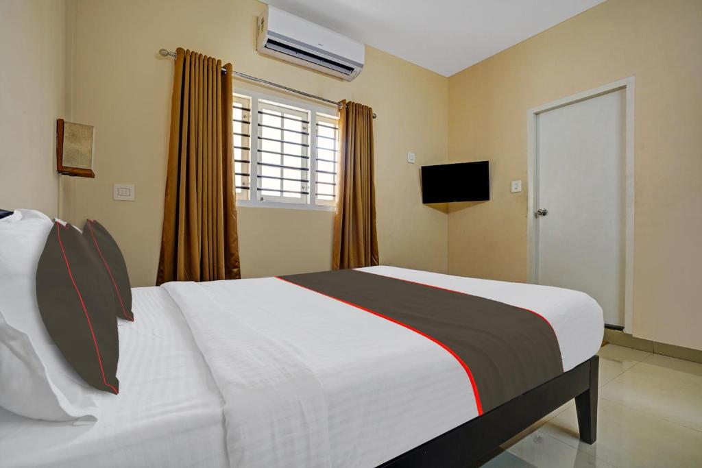 a bedroom with a bed and a window and a television at Collection O Lux villa in Nedumbassery