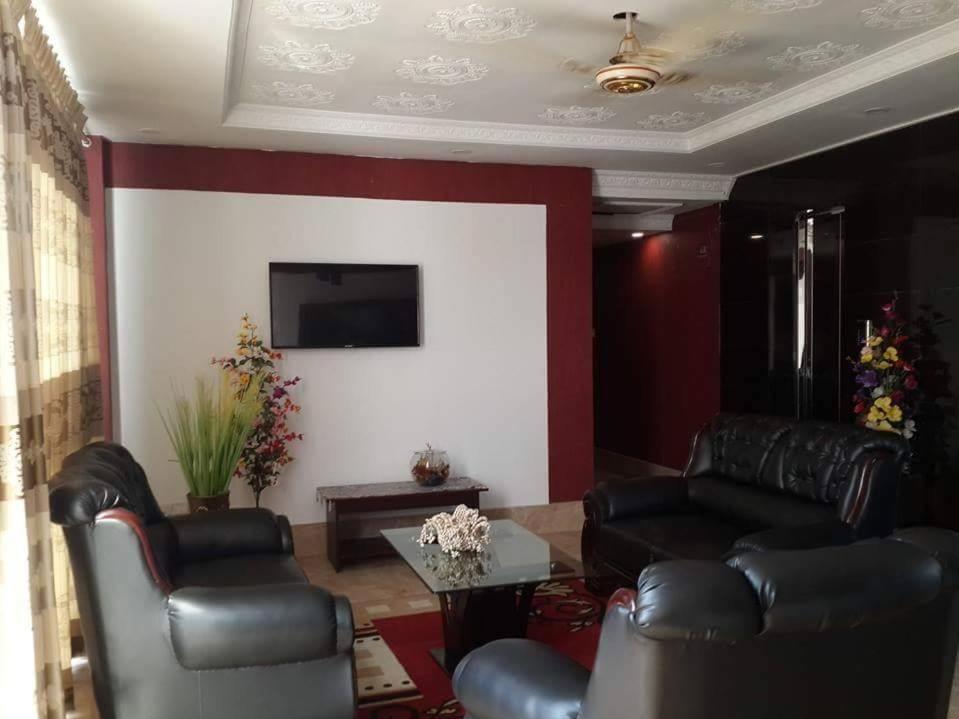 a living room with leather chairs and a flat screen tv at 78 Firoza Inn in Dhaka