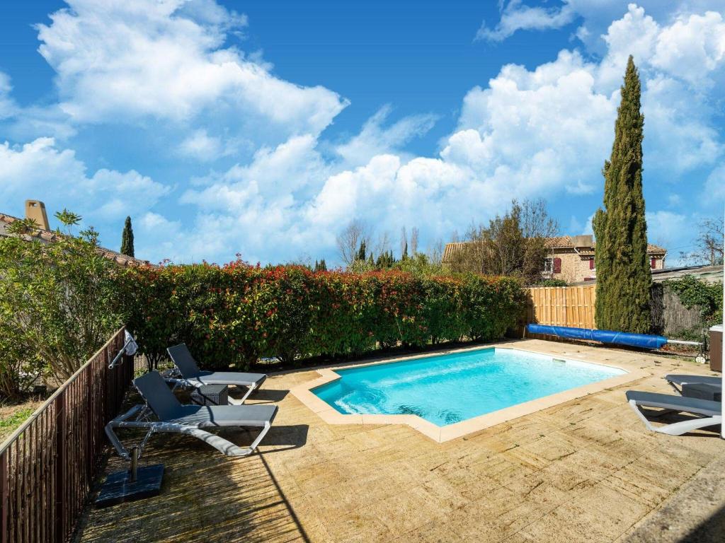 une piscine avec deux chaises et une clôture dans l'établissement Villa Chardonnay, à Montbrun-des-Corbières