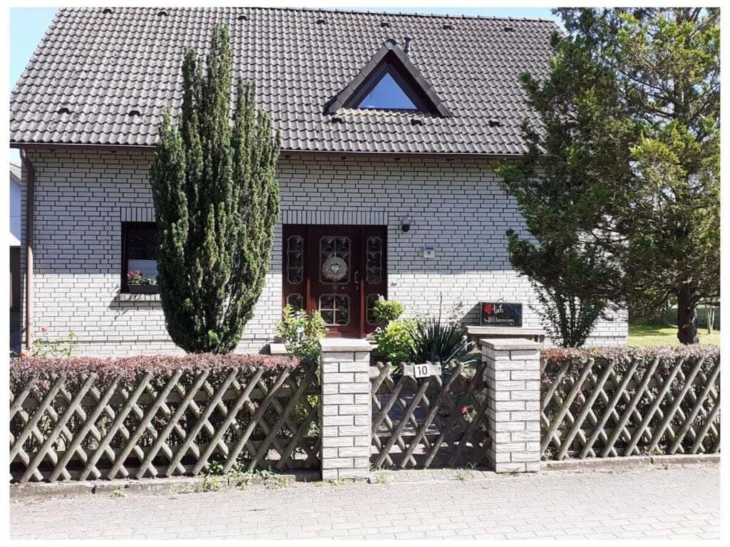 a house with a fence and a black door at "Lake view" Modern retreat in Torgelow am See