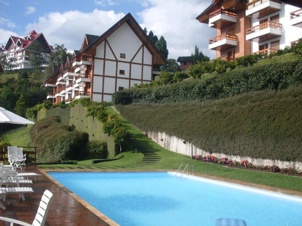 a large swimming pool in front of a building at Apartamento para temporada no Alto do Capivari in Campos do Jordão