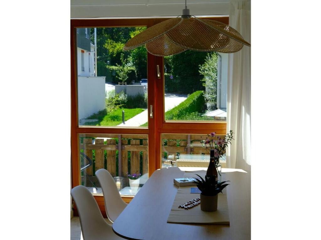 uma sala de jantar com uma mesa e uma grande janela em Dream vacation on Lake Ammersee em Schondorf am Ammersee
