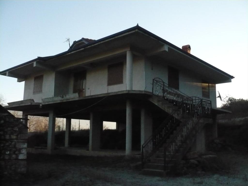 a house with a staircase in front of it at Village Villa with National Park View in Librazhd