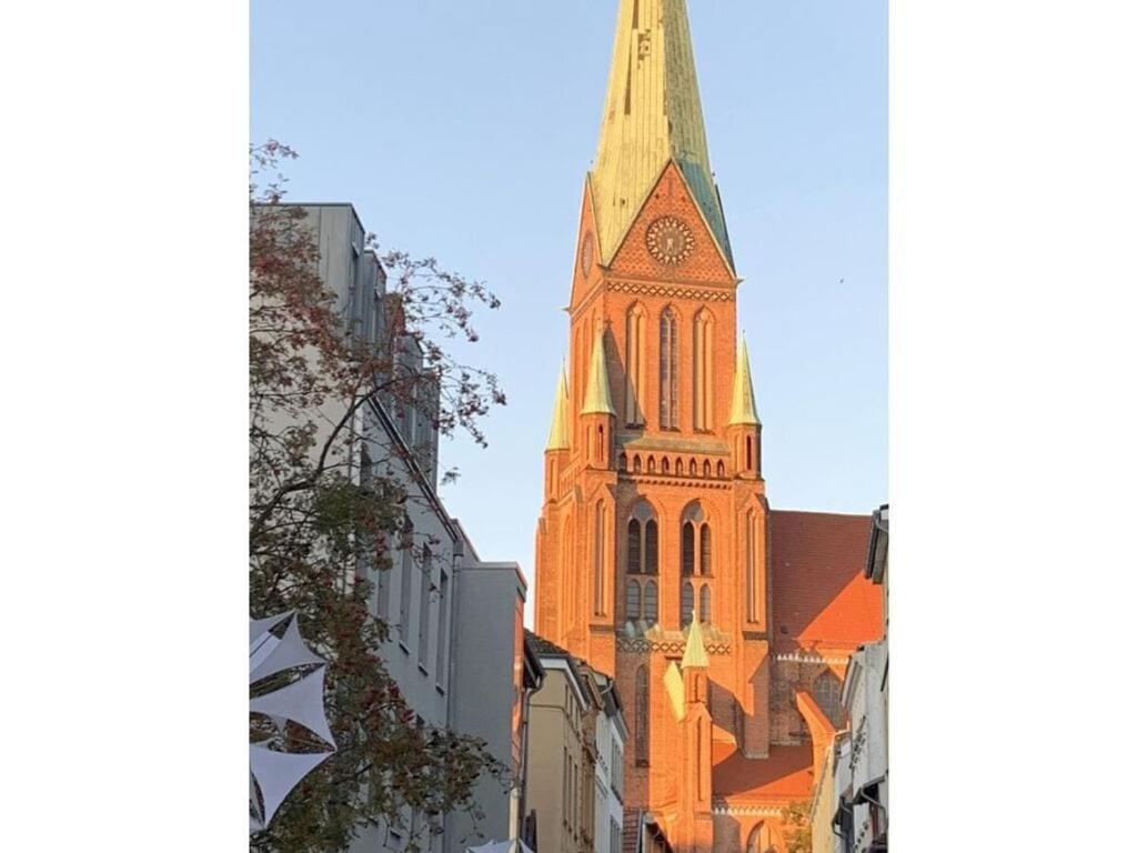 an orange church steeple with a clock on it at CATHEDRAL WHISPERS Modern retreat in Schwerin