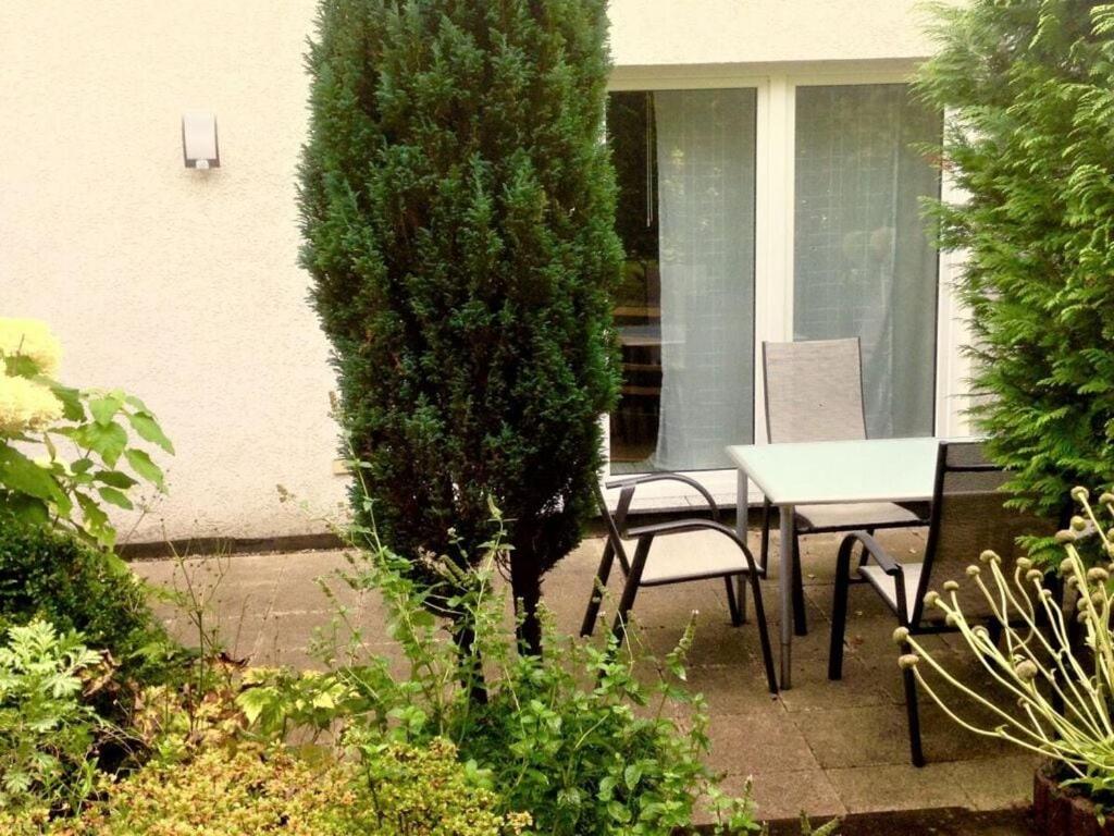 eine Terrasse mit einem Tisch, Stühlen und einem Baum in der Unterkunft Am Königsberg, Luebeck in Lübeck