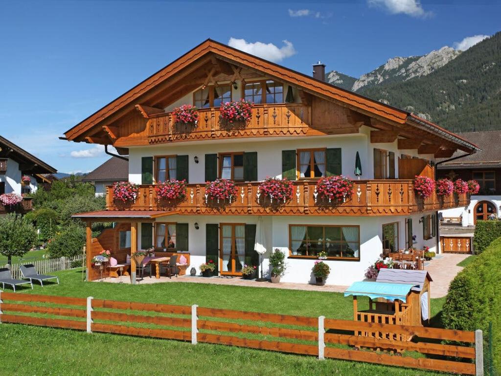 a large house with a fence in front of it at Holiday apartment "Wetterstein" in Krün