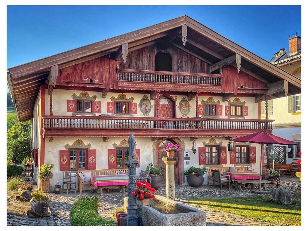 a large wooden house with a patio in front of it at MAX in the Schusterhäusl in Achenmühle