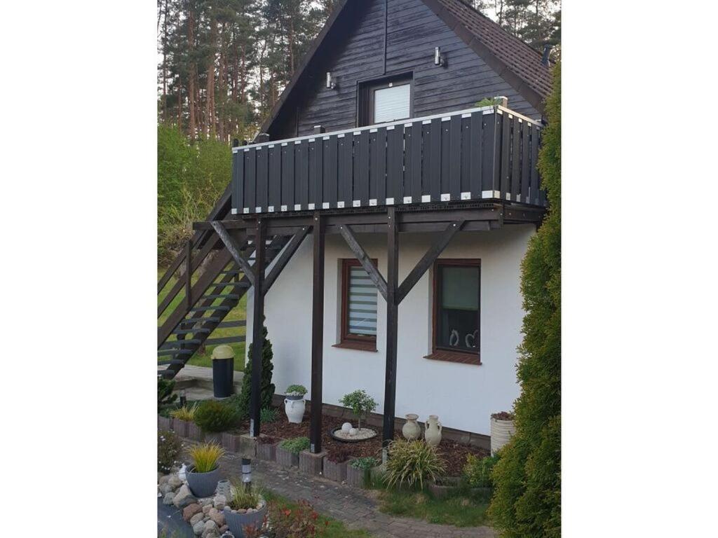 una casa con balcón en la parte superior en Holiday apartment by the forest en Kölpinsee