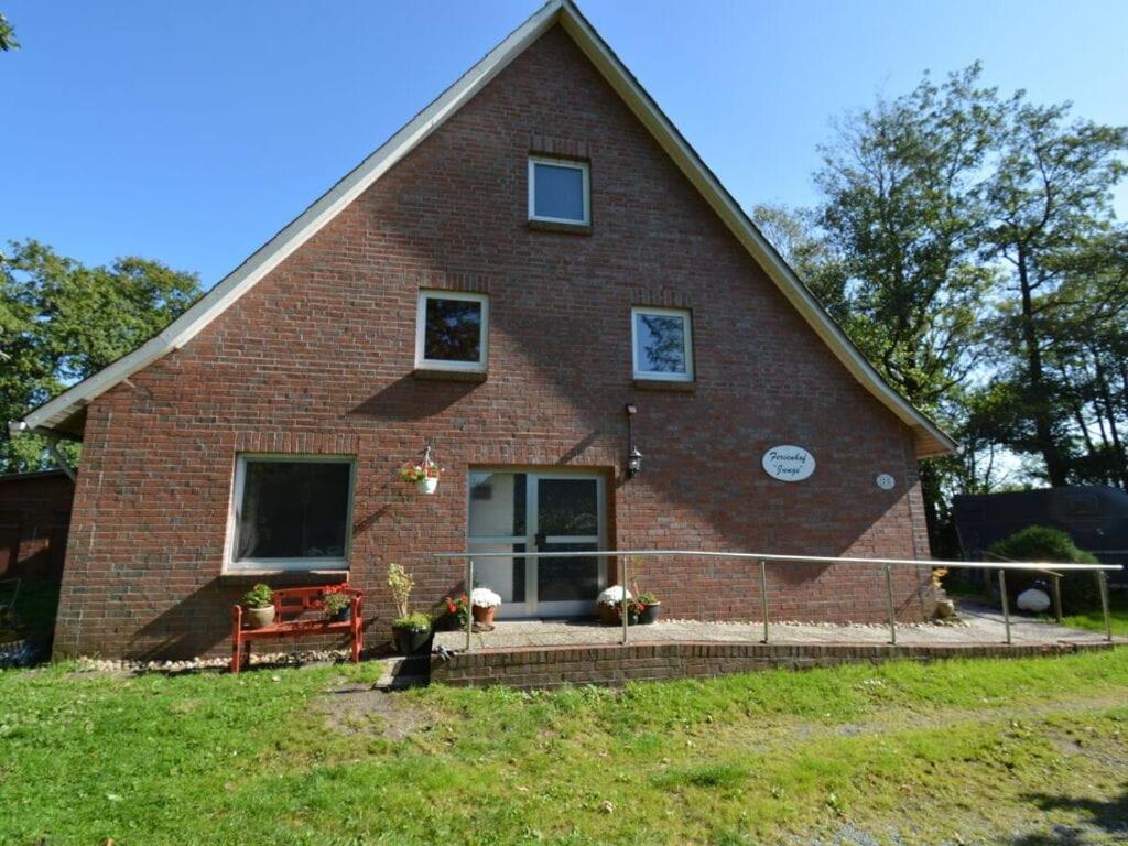 une maison en brique rouge avec une cour d'herbe dans l'établissement Ferienhof Junge Modern retreat, à Wingst