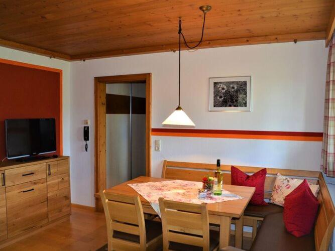 a dining room with a table and a television at Nice apartment in Bavaria in Oberstaufen