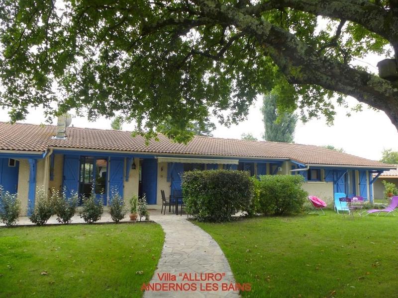 a blue house with a lawn in front of it at Villa Alluro in Andernos-les-Bains