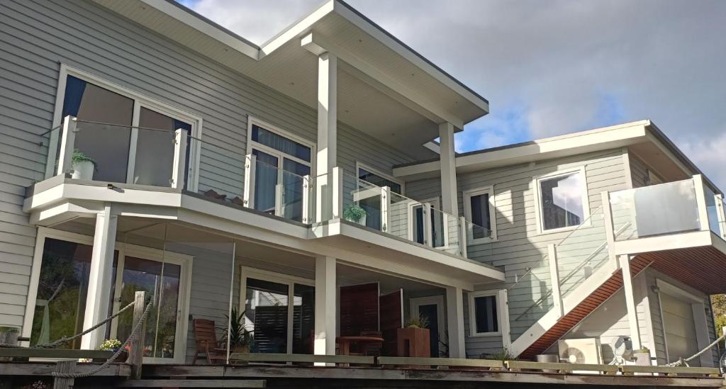a large house with a porch and balcony at New luxury waterfront accommodation in Dunedin