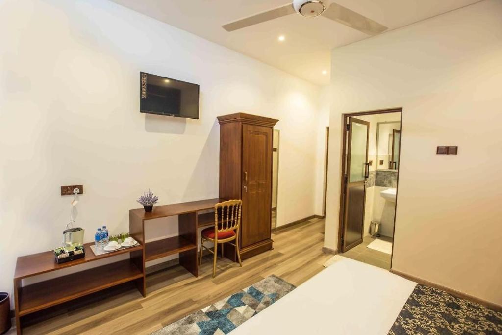 um quarto de hotel com uma secretária e uma cama em Lotus Grand View Hotel em Horana