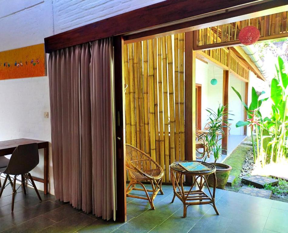 een kamer met een patio met een tafel en stoelen bij Pool House Studios in Kuta Lombok