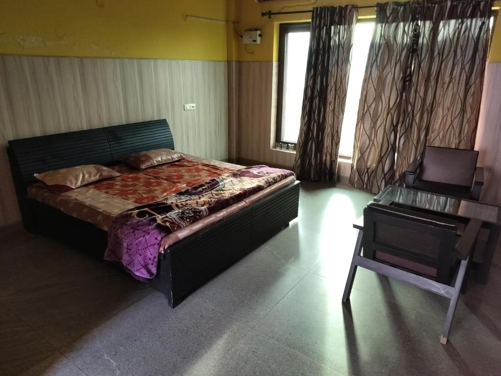 um quarto com uma cama e uma secretária ao lado de uma janela em Kingston banquet and event center em Kurukshetra