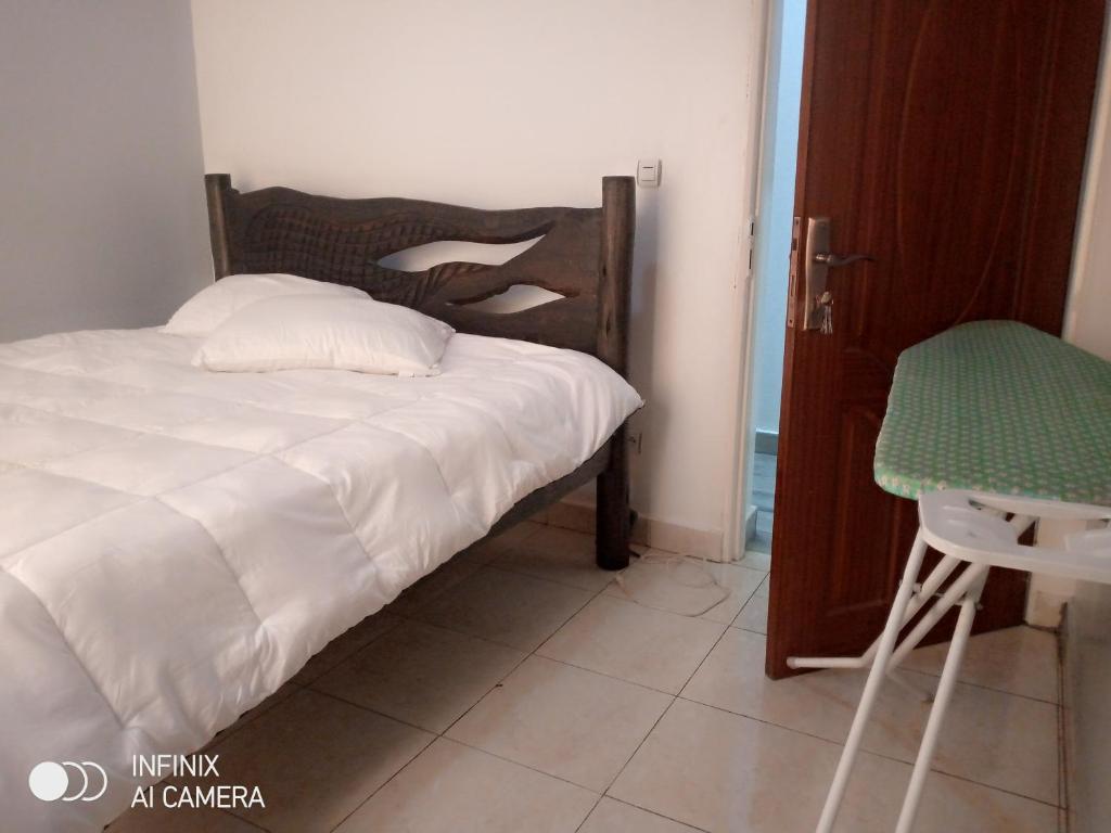 a bedroom with a bed and a chair next to a door at Remera in Kigali