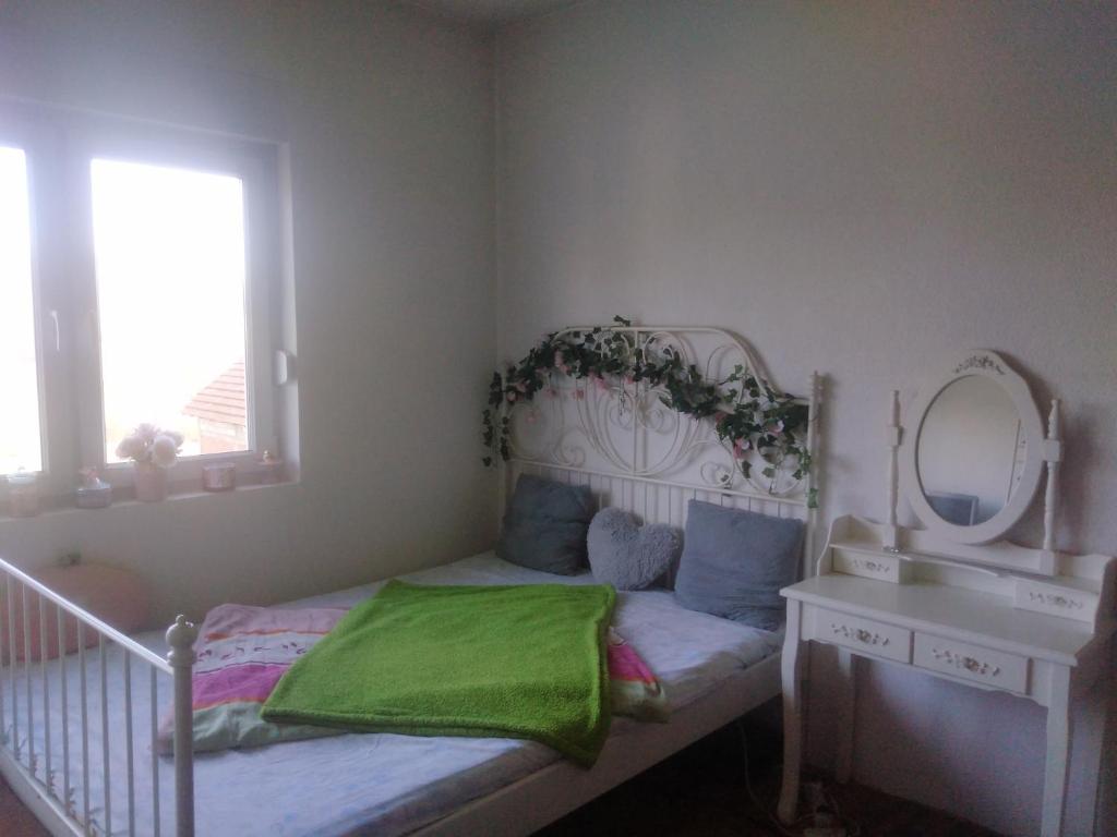 a small bedroom with a bed and a mirror at Landhaus in Bosanska Dubica