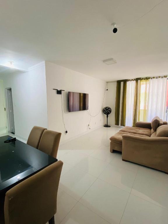 een woonkamer met een bank en een tafel bij Apartamento Amplo Luzia Próx Shopping Jardins in Aracaju