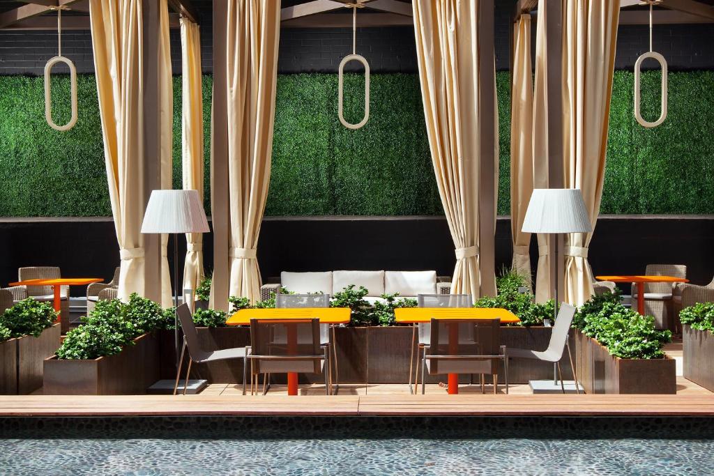 a restaurant with yellow tables and chairs and plants at Sheraton Grand Los Angeles in Los Angeles