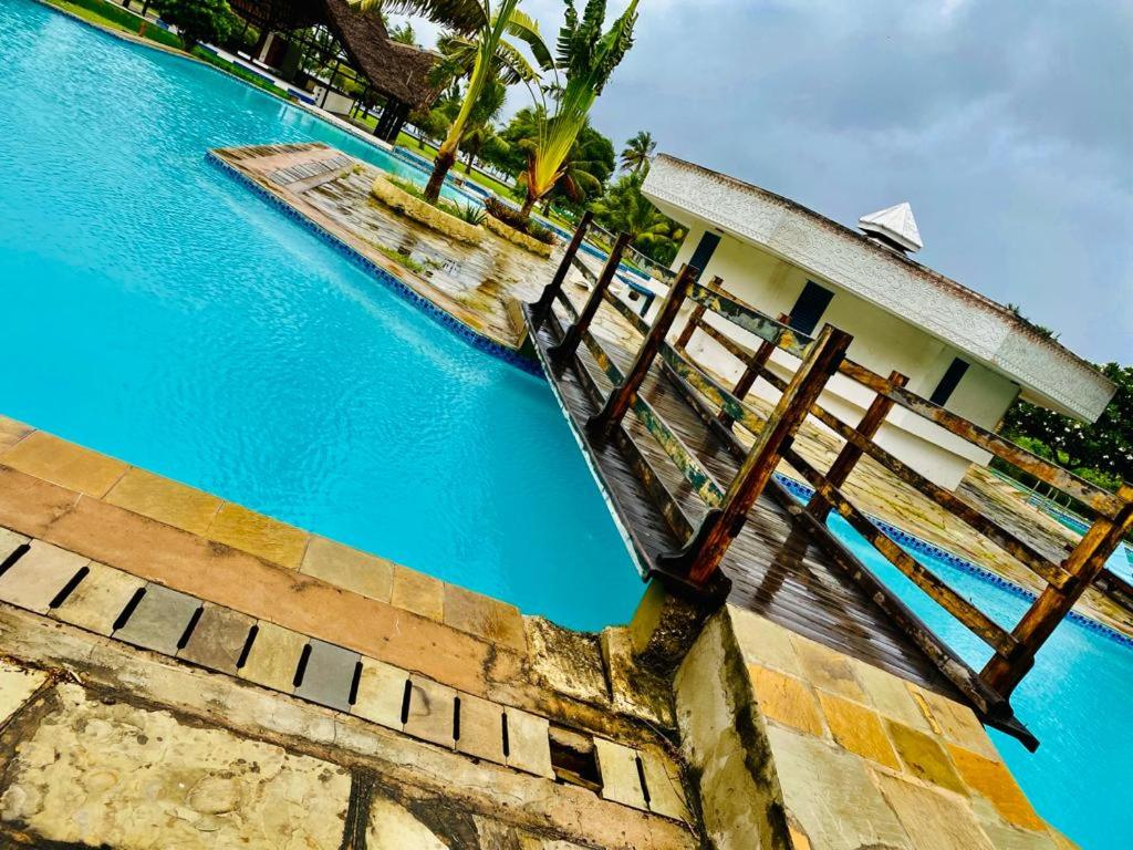 een uitzicht op een zwembad met een huis bij Bliss Palace in Diani Beach