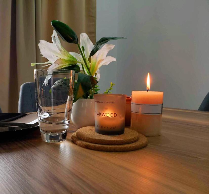 une table avec deux bougies, un vase et un verre dans l'établissement Apartment DEVA, à Balchik