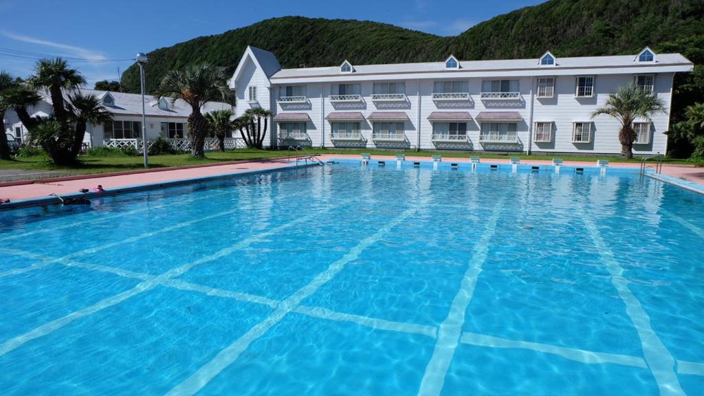 una gran piscina frente a un edificio en パームビーチリゾートホテル en Oshima