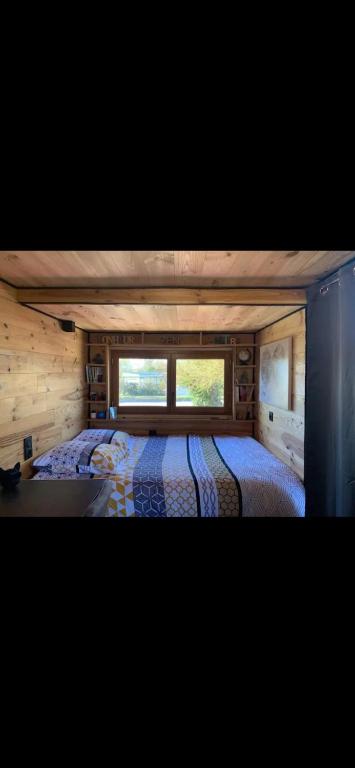 ein Schlafzimmer mit einem Bett in einem winzigen Haus in der Unterkunft La Tiny house in Ardres