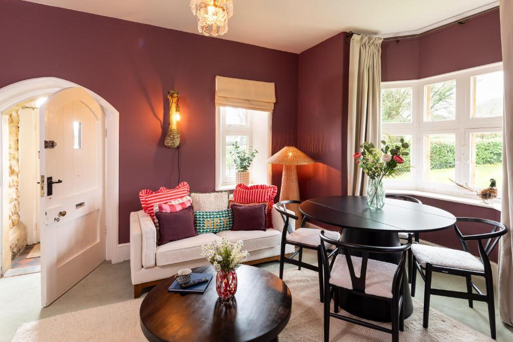 a living room with purple walls and a table and chairs at Estate Lodge Sleeps 5 on The Jurassic Coast Devon in Sidbury