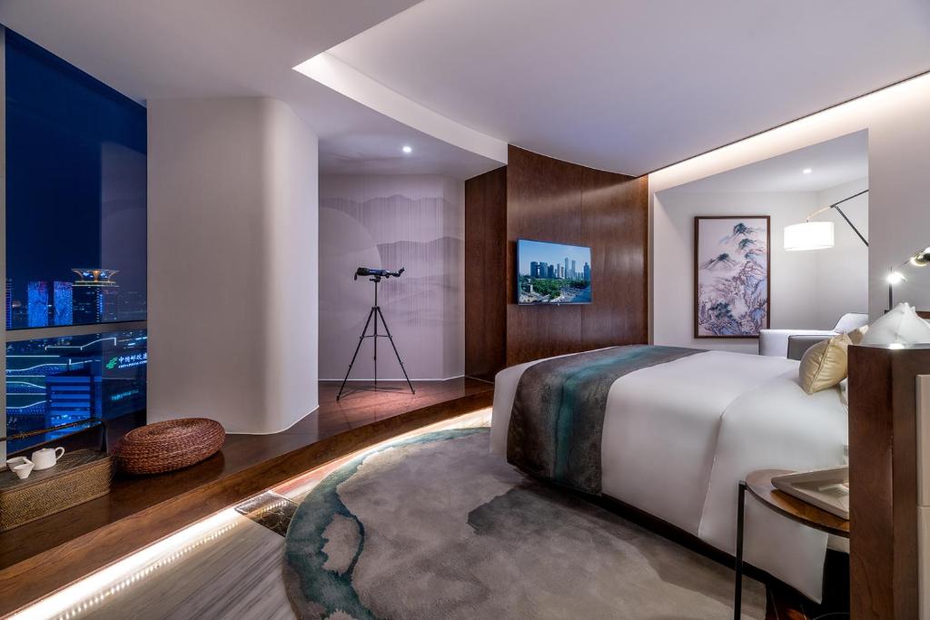 um quarto de hotel com uma cama e uma câmara em New Century Hotel Qianchao Hangzhou em Hangzhou