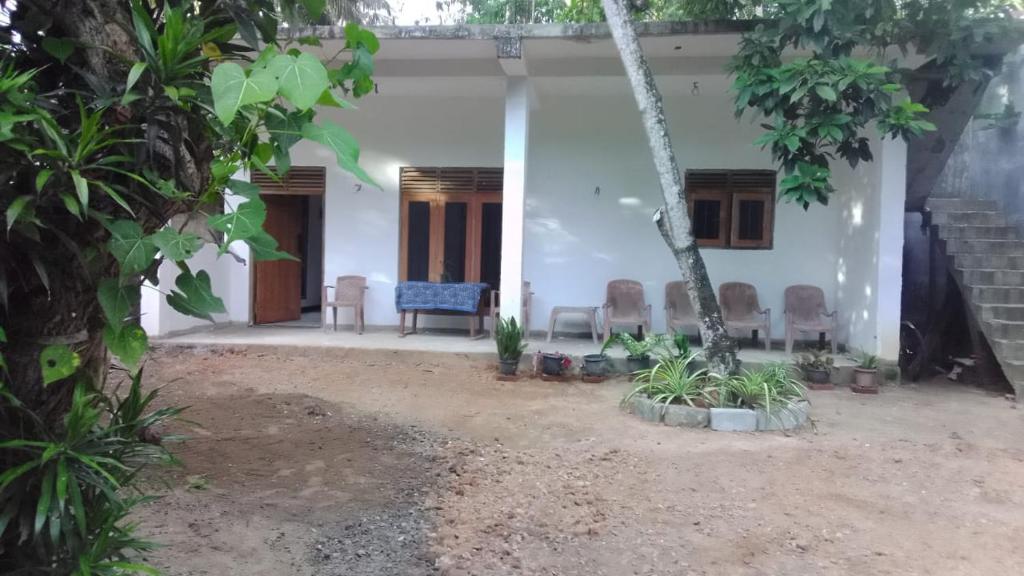 una casa con sillas delante en Wijesingha Holiday Home, en Weligama
