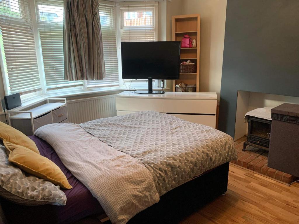 a bedroom with a bed and a flat screen tv at Private Lovely double bedroom in High Wycombe