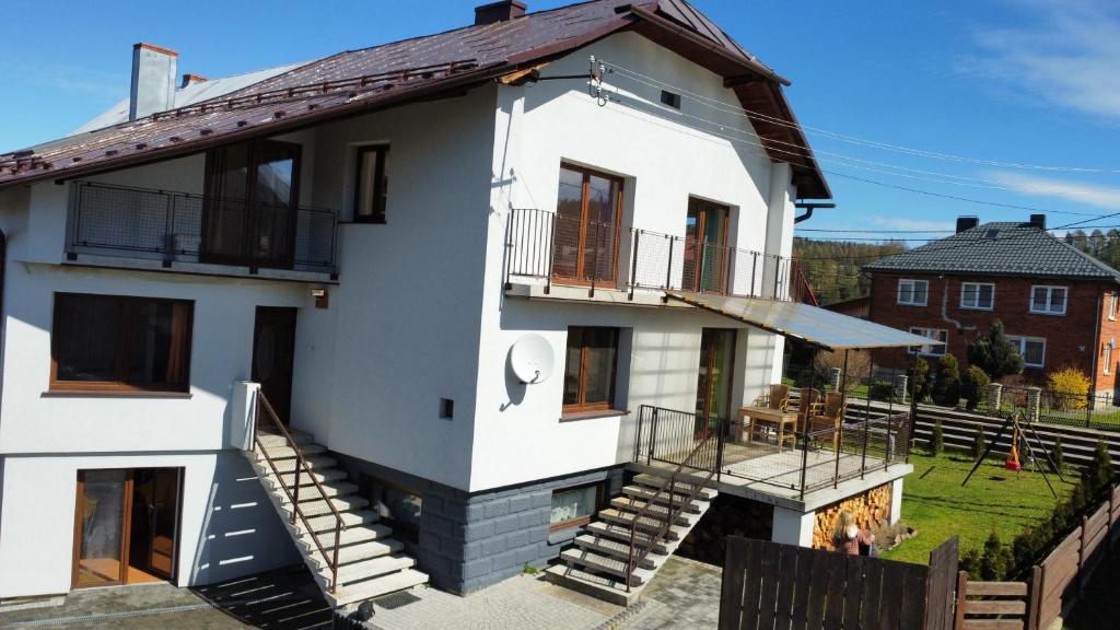 a white house with stairs leading up to it at Dom, Apartamenty, Agroturystyka in Kacwin