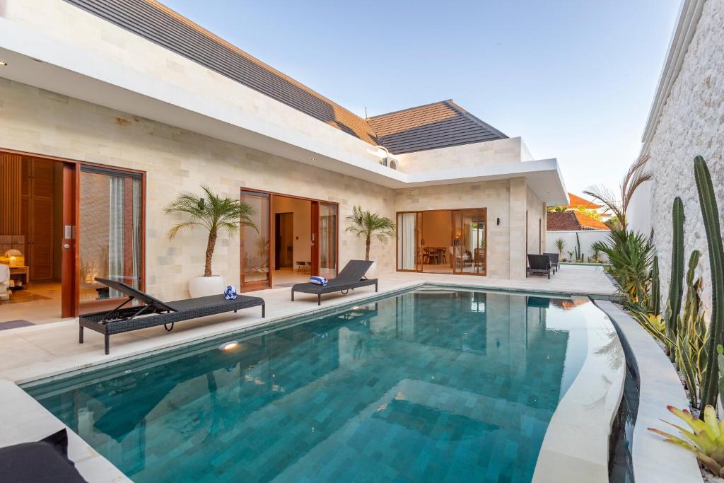 a swimming pool in a villa with a house at The Clara Ville in Canggu