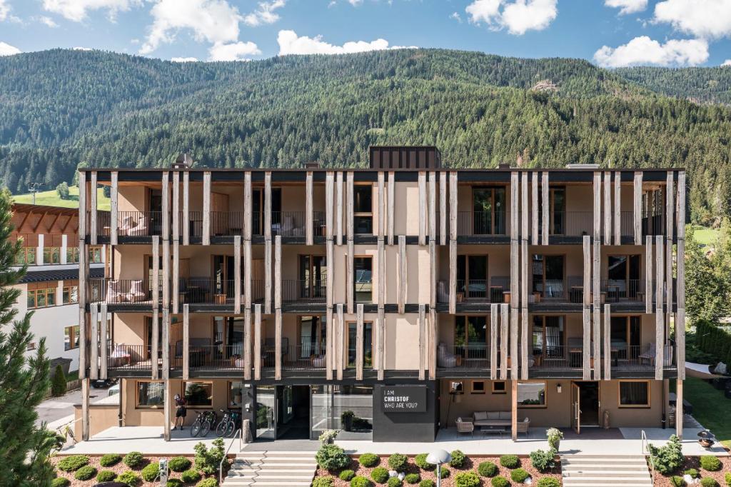 un edificio de apartamentos con una montaña en el fondo en Hotel Christof, en Monguelfo-Tesido