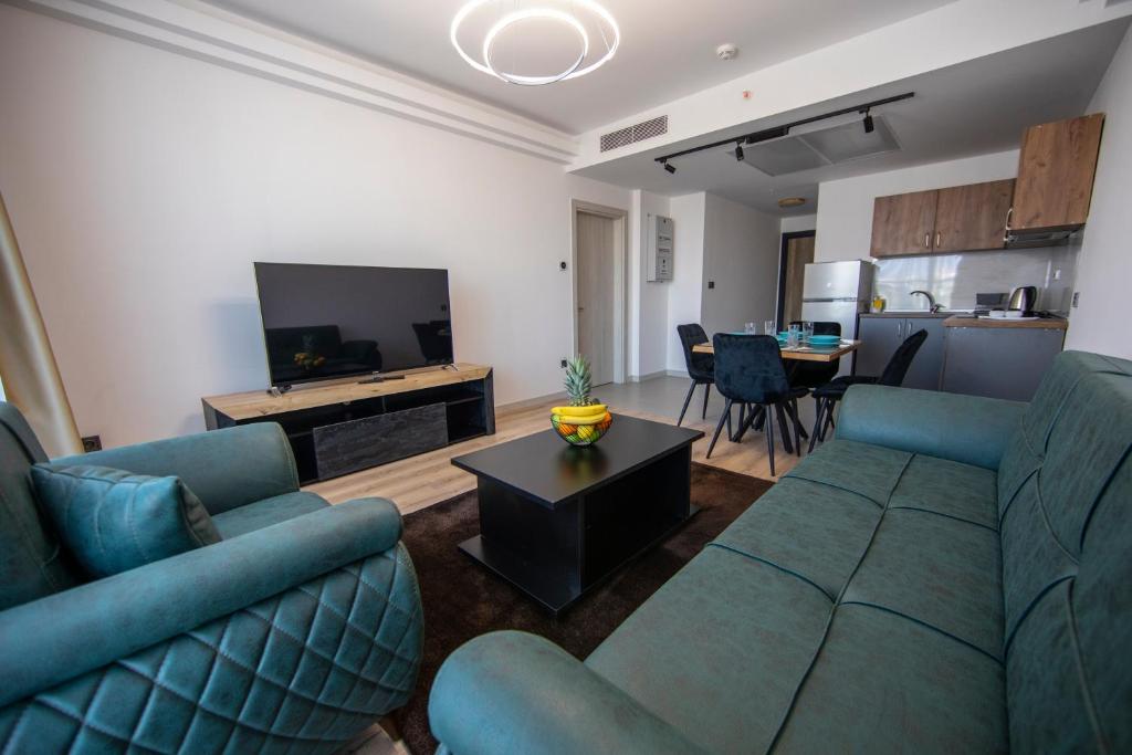 uma sala de estar com dois sofás azuis e uma televisão em CEVAHIR SKY CITY Skopje JK Apartments em Skopje