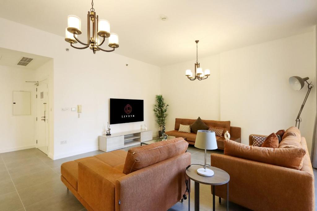 un soggiorno con 2 divani e una TV di Livbnb- Homely 3+1 in Heart of JBR, Close to Beach a Dubai