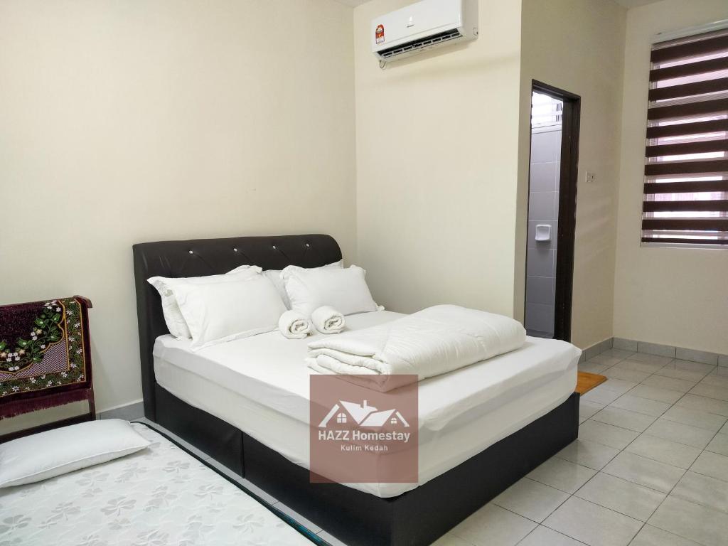 a bed in a room with a box on it at HAZZ Homestay Kulim in Kulim
