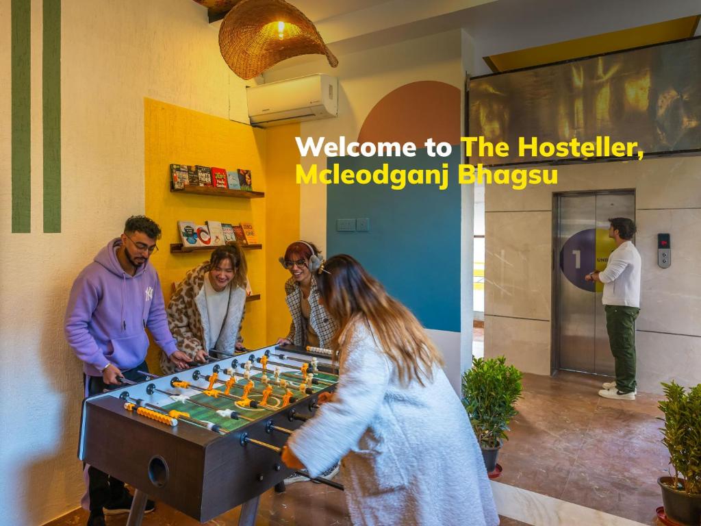 un groupe de personnes jouant à un jeu de contrôleurs dans l'établissement The Hosteller Mcleodganj, Bhagsu, à McLeod Ganj