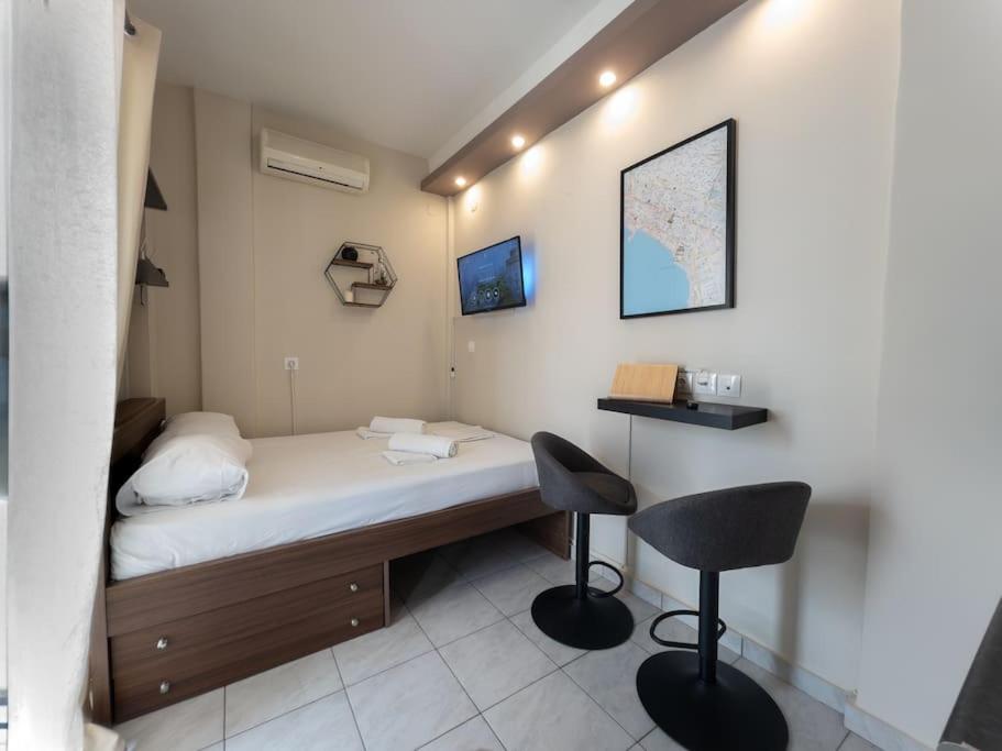 a room with a bed and a desk and two chairs at BedCity Apartment with Free Parking in the City Center in Thessaloniki
