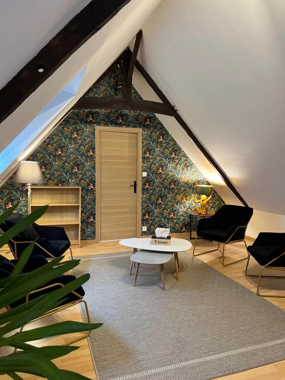 a room with a table and chairs in a attic at Flor du Mont Gîte in Pontorson