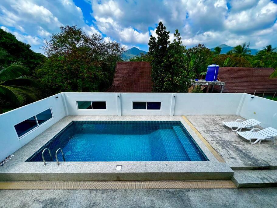 - une piscine avec 2 chaises longues à côté dans l'établissement The Wok Tum Manor!, à Ko Pha Ngan