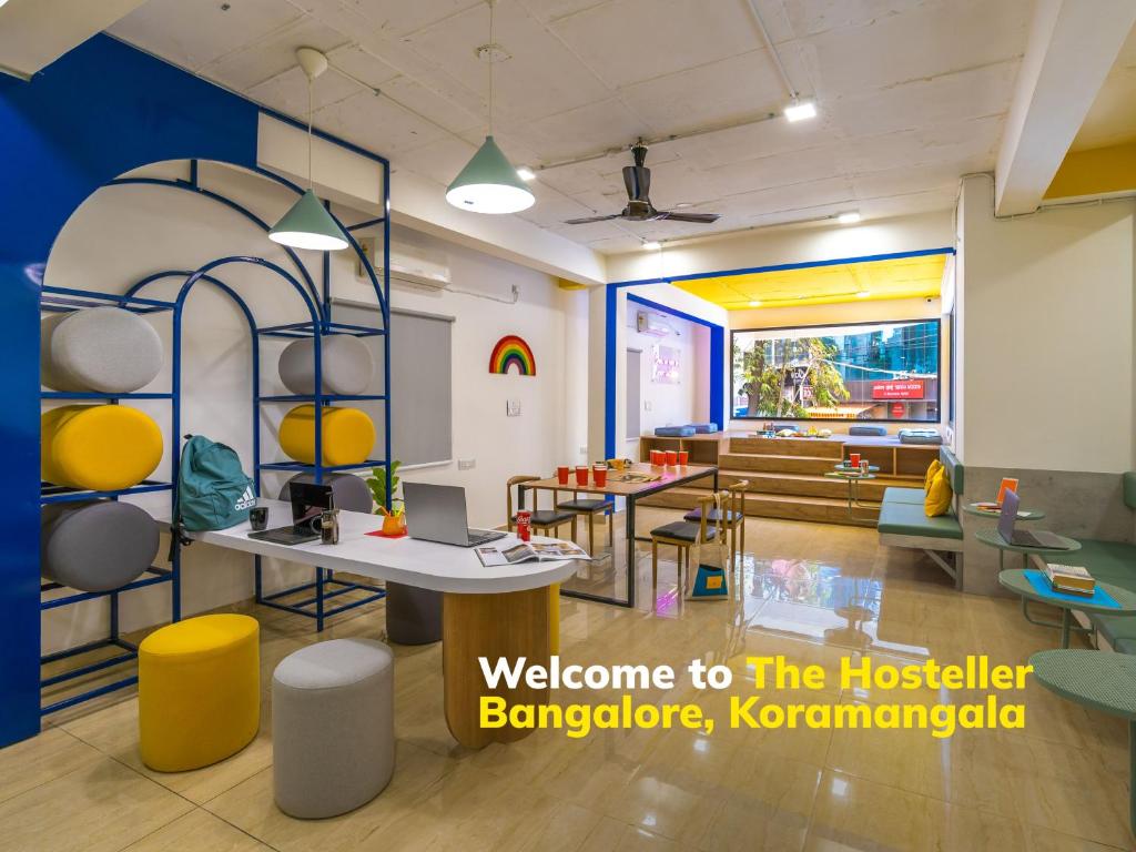 バンガロールにあるThe Hosteller Bangalore, Koramangalaのテーブル、椅子、ソファが備わる客室です。