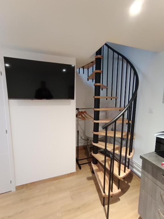 ein Wohnzimmer mit einer Treppe und einem TV in der Unterkunft jolie maison neuve - malisone - in Pont-Sainte-Maxence