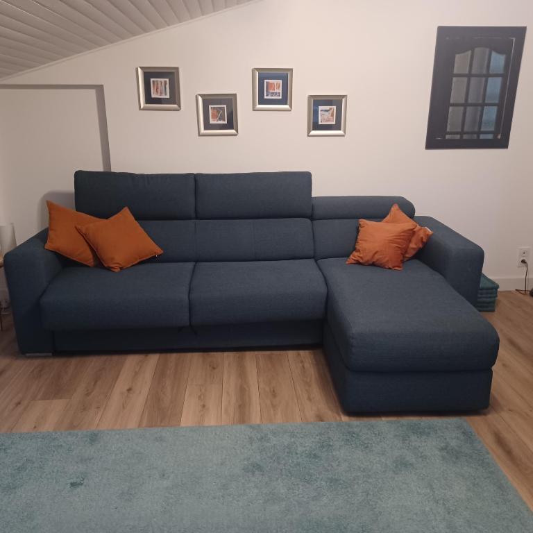 a blue couch with orange pillows in a living room at St Loup in Bessan