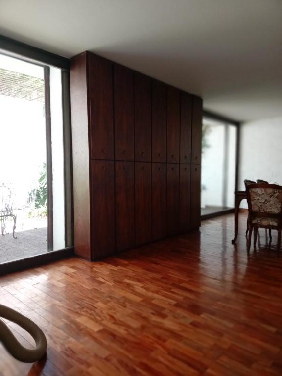 ein leeres Zimmer mit Holzböden und einem großen Fenster in der Unterkunft EnBenegas in Mendoza
