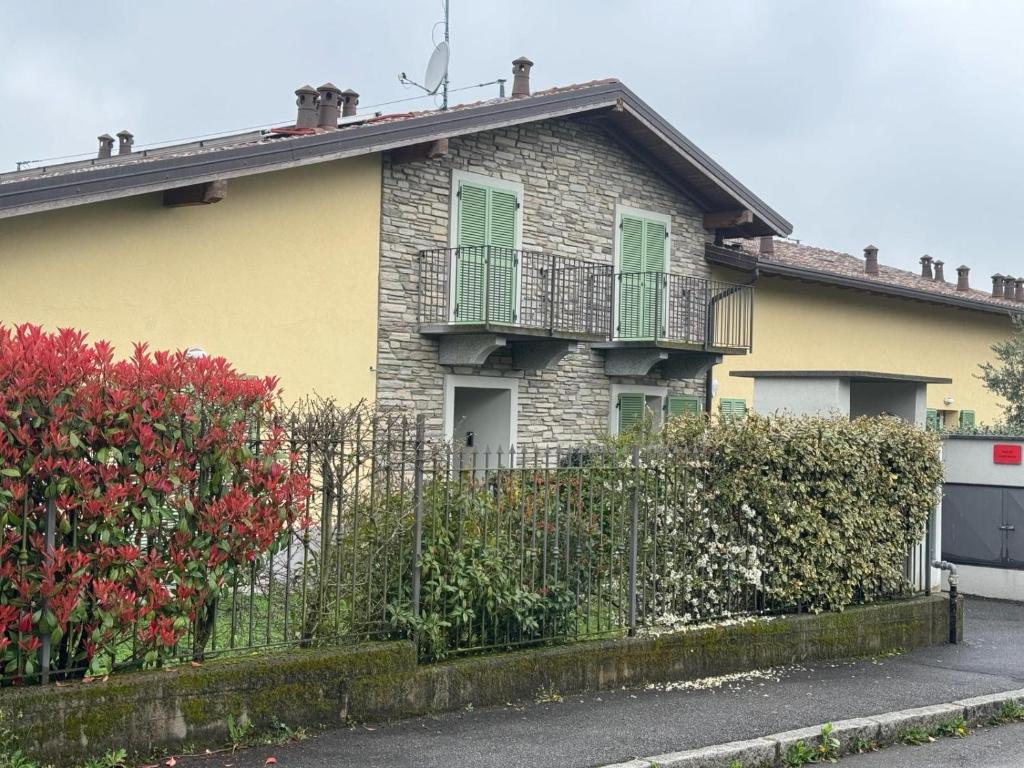 une maison en briques avec une clôture devant elle dans l'établissement Park 20 Guest House, à Azzate