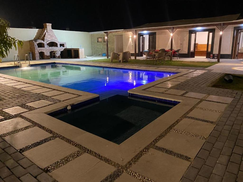 una piscina en un patio por la noche en شاليه للايجار اليومي بالريف الاوروبي en Qaryat ash Shamālī
