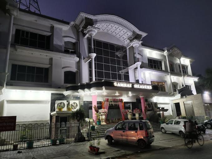 a car parked in front of a building at night at Hotel Samrat Heavens Meerut in Meerut